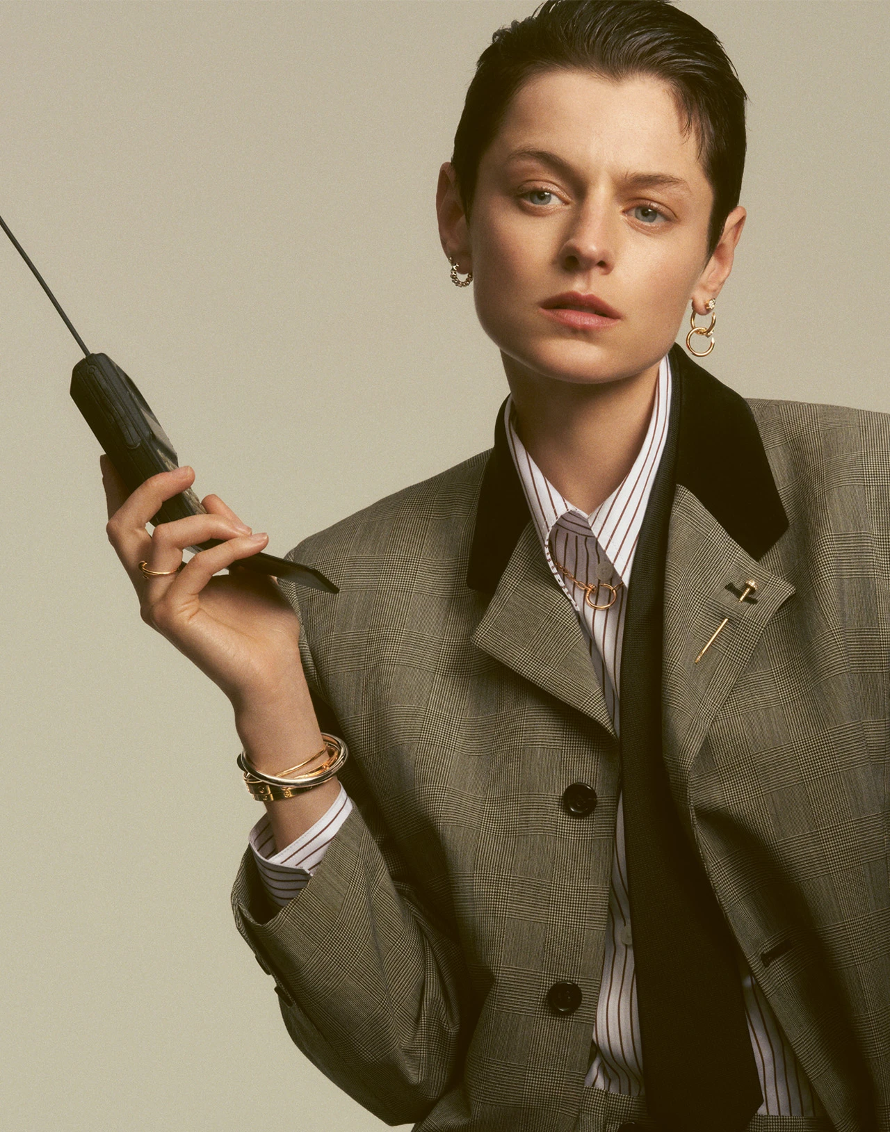 Photo of Emma Corrin wearing the Juste un Clou lapel pin, bracelet, necklace, earrings and ring, complemented by the Clash de Cartier earrings